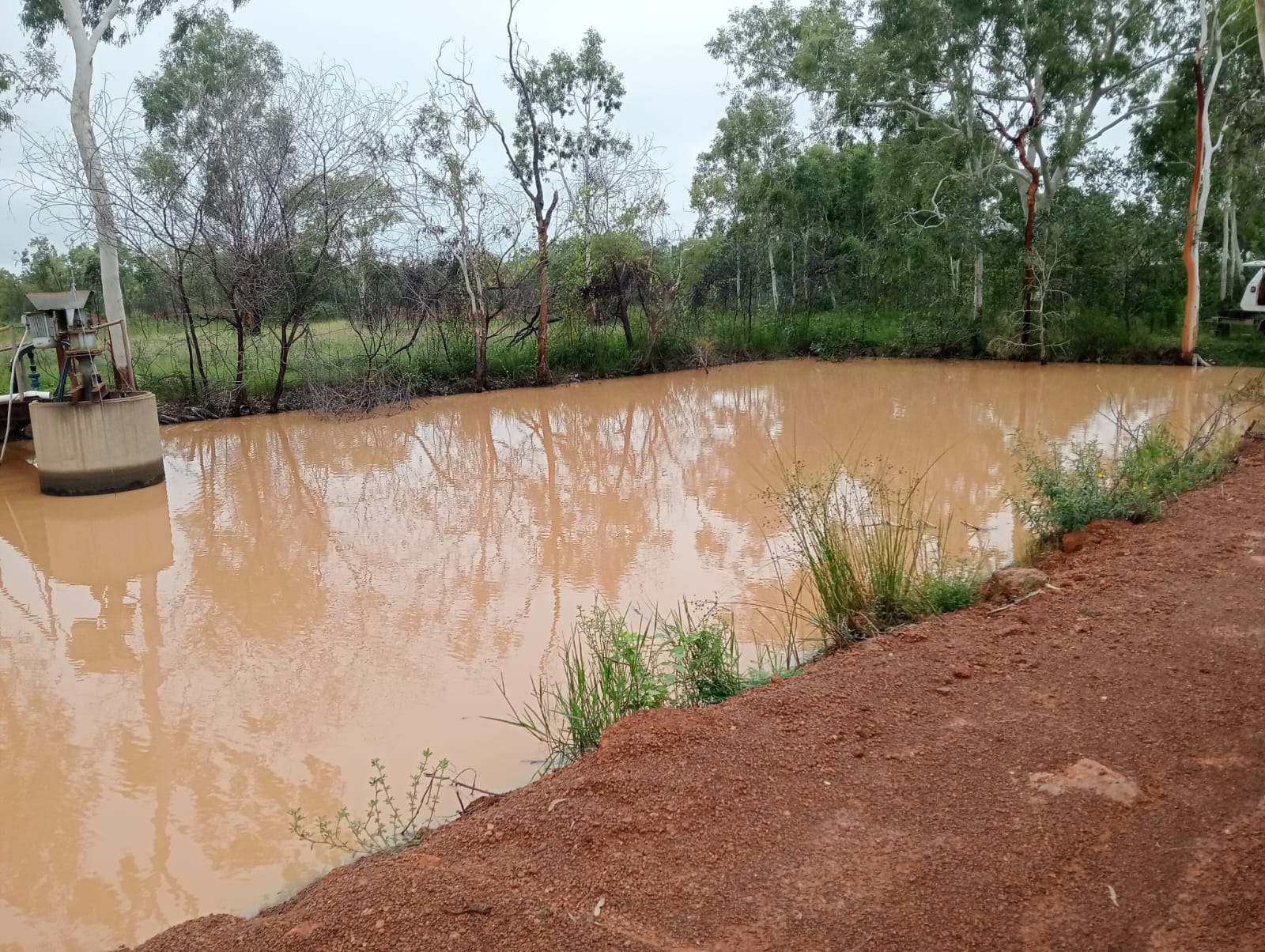 Earthen sediment settling pond receiving iron-rich tank cleaning wastewater on a remote Australian site