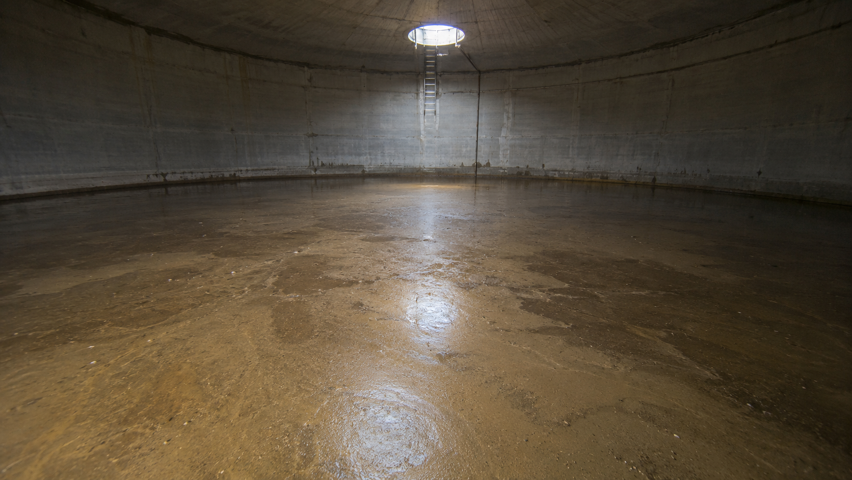 Sediment accumulated across the floor of a potable water storage tank