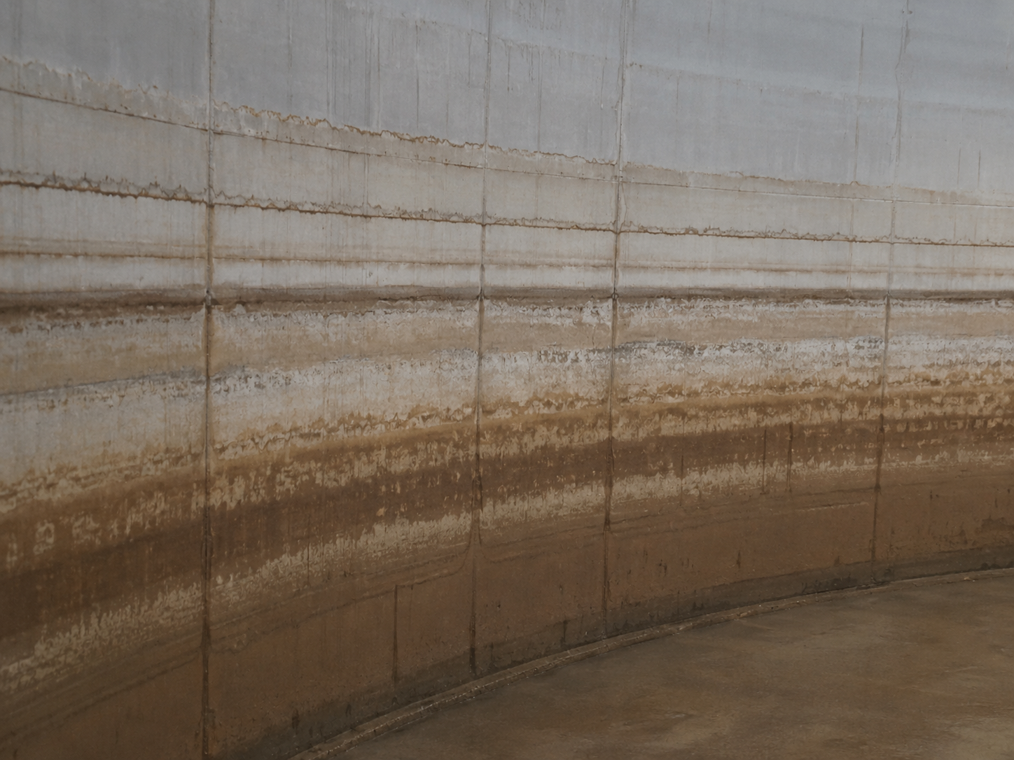 Sediment banding on the internal wall of a water tank at repeated standing water levels