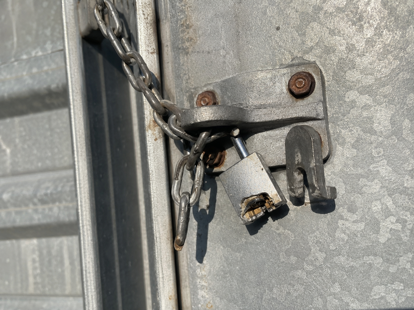 Broken padlock on a water tank access point indicating unauthorised entry